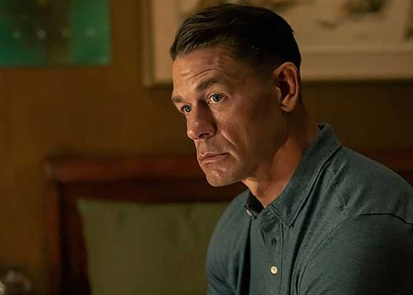 John Cena as Chris looking thoughtfully while sitting on his bed in Peacemaker season 2
